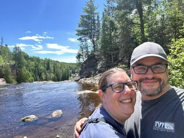 James and Erin Caldwell outdoors on a summer river walk